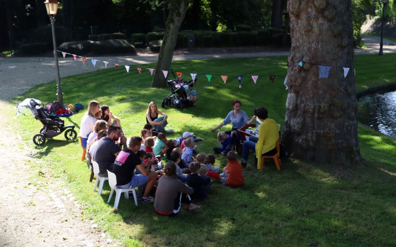 Un groupe écoute des histoires au bord de l'étant du parc communal de Péruwelz