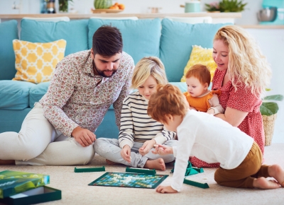 famille qui joue au scrabble par terre dans le salon