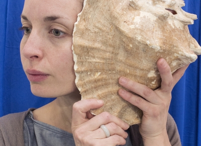 La comedienne écoutant un coquillage à l'oreille